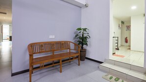 A wooden bench, a potted plant, and a staircase leading to an entrance.
