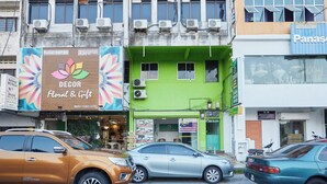 A building with multiple shops, including a floral and gift store, and a sign for a furniture store.