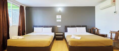 A hotel room with two beds, a nightstand, a wooden chair, and a window with curtains.