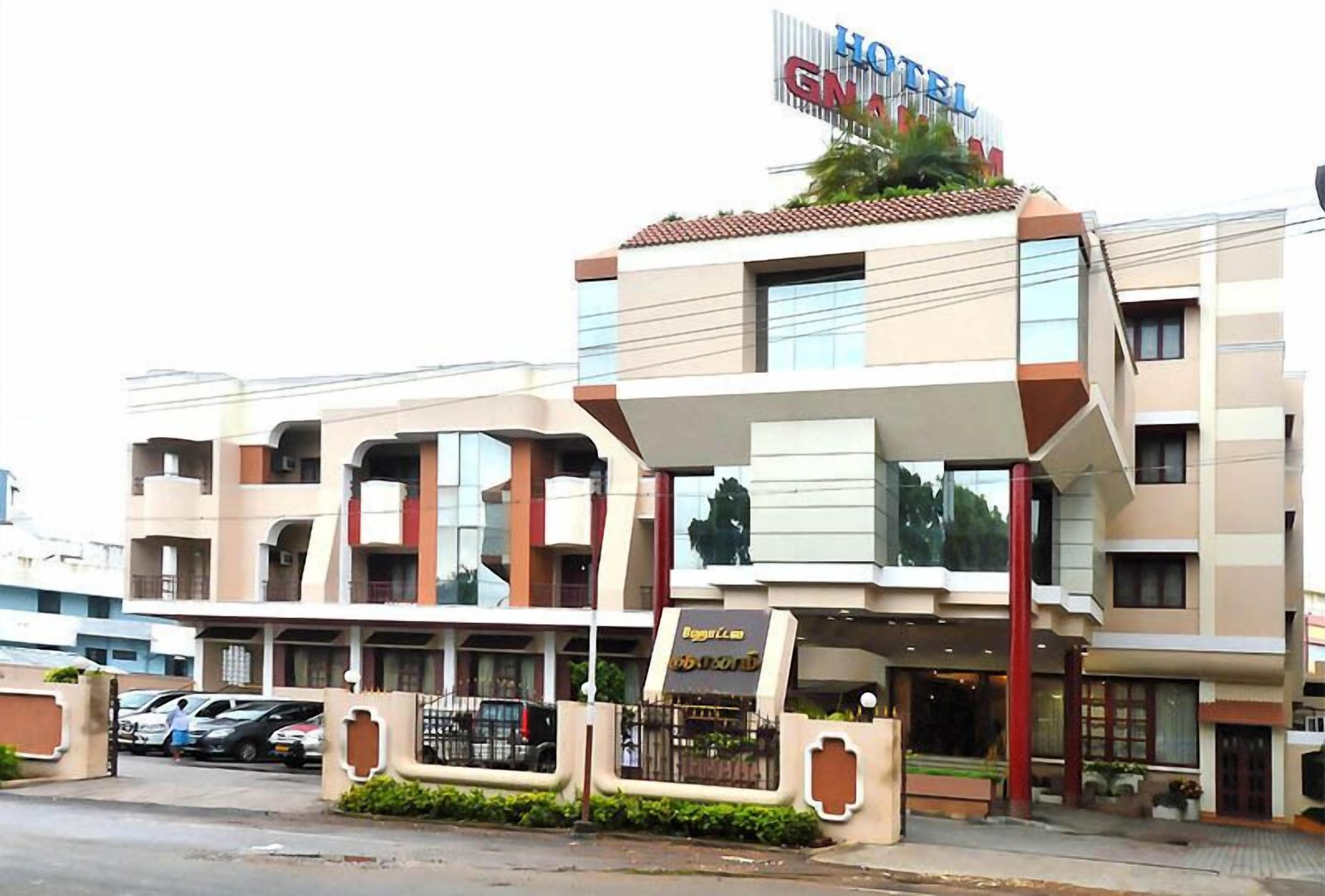 A hotel with a modern facade, multiple balconies, and a sign indicating a restaurant on the ground floor.
