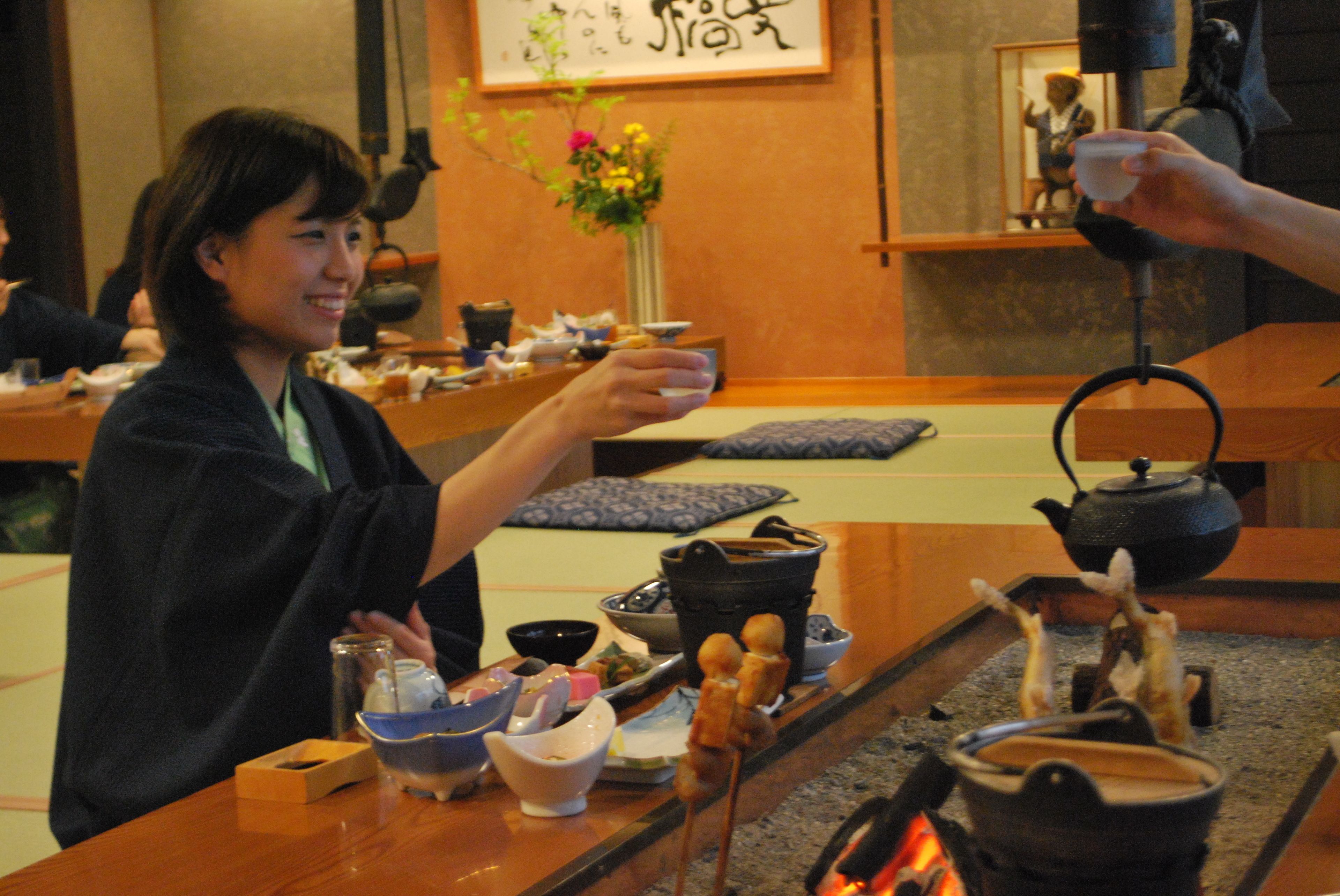 A traditional Japanese tea ceremony setting with a table set for tea, a teapot, and various tea utensils.