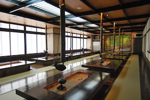 Ein traditioneller japanischer Raum mit Tatami-Matten, niedrigen Tischen und Schiebetüren.