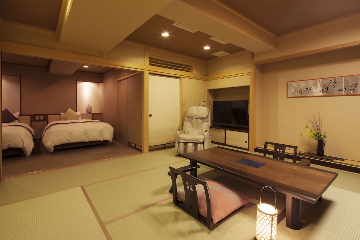 A traditional Japanese-style room with tatami flooring, a low table, and a sofa.