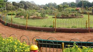 A garden with raised flower beds and a metal fence. - Hotel Aksa (Mumbai)