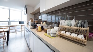 Eine moderne Küche mit einer Arbeitsplatte, auf der Teller, Tassen und eine Kaffeemaschine stehen.
