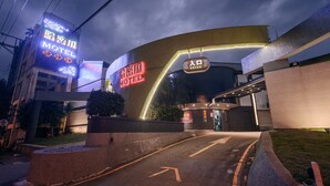 Un motel con una entrada curva, letreros de neón y una clara señalización que dice 'ENTRAR'.