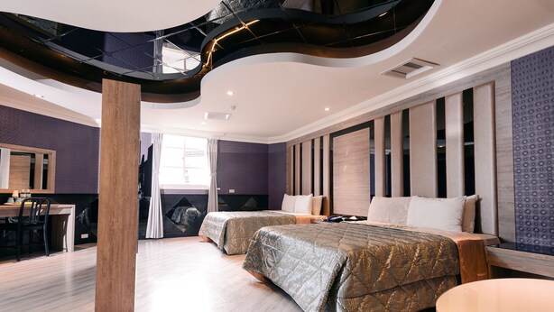 Una habitación de hotel moderna con dos camas, una zona de comedor y una escalera.