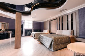 A modern hotel room with two beds, a dining area, and a staircase. - Cantaloupe Motel (Taoyuan City)