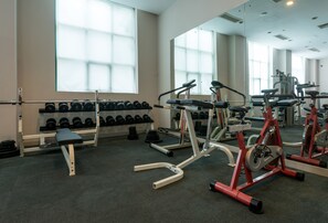 Ein Fitnessstudio mit Gewichten, Kurzhanteln und Laufbändern.