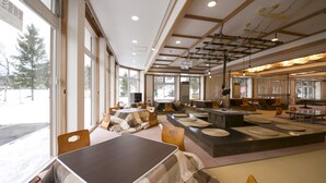A spacious indoor area with large windows, wooden beams, and a central island with seating. - Rosen Heim HAKUBA (Hakuba)