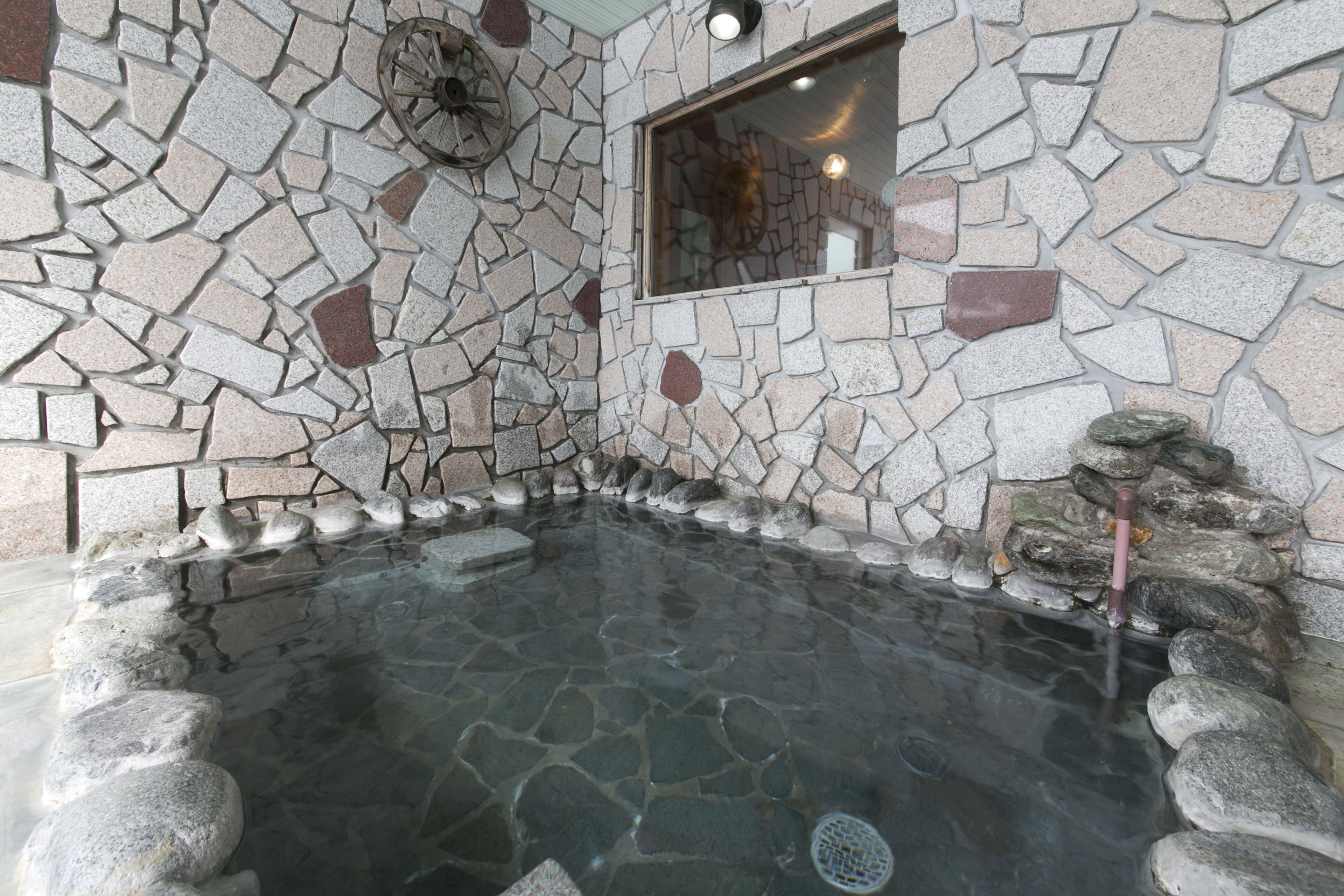 A stone-walled hot tub with a clear view of the surrounding area.