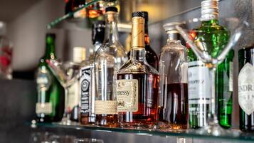 A bar with various bottles of liquor and glasses.