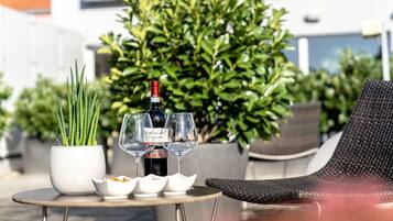 A table with a bottle of wine, glasses, and a small potted plant.