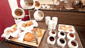 A breakfast buffet with various food items, including pastries, bread, and condiments.