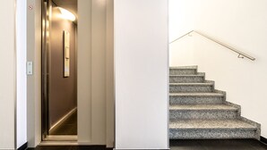A modern interior with a staircase and an elevator.