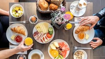 A breakfast setting with various food items and beverages on a table.