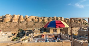 A rooftop terrace with a view of a historic fort.