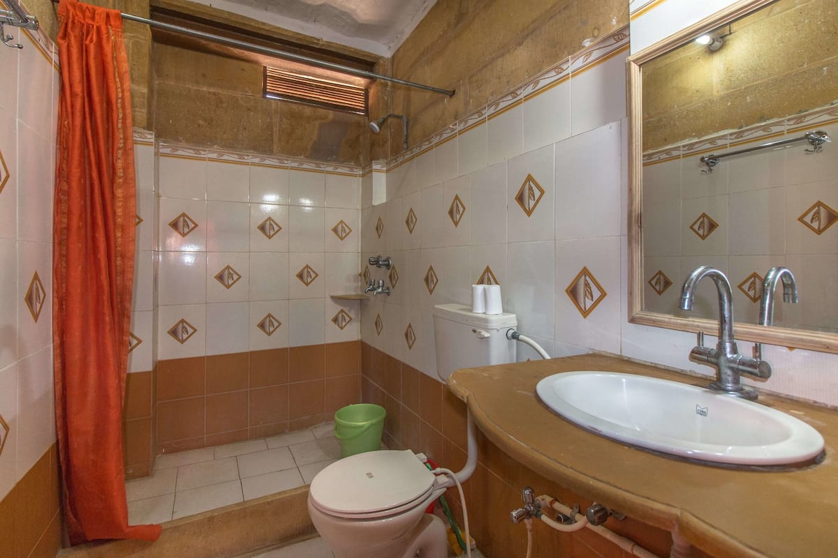 A bathroom with a toilet, sink, and shower area.