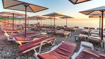Vlak bij het strand, ligstoelen aan het strand, parasols