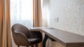 A modern room with a desk, chair, and patterned wallpaper.