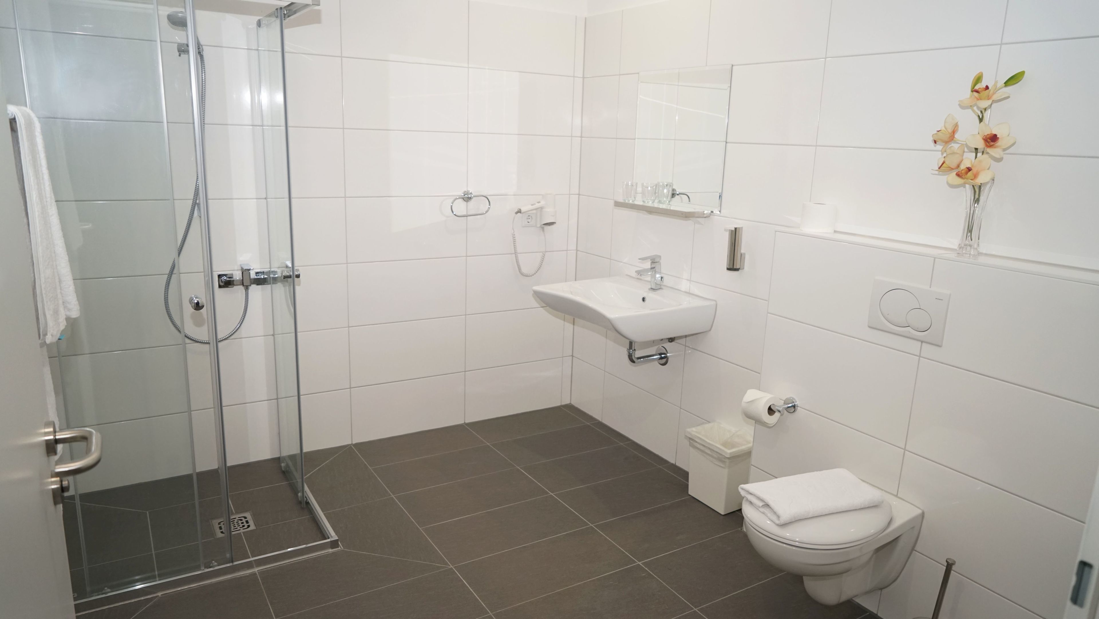 shower, hair dryer, slippers, towels