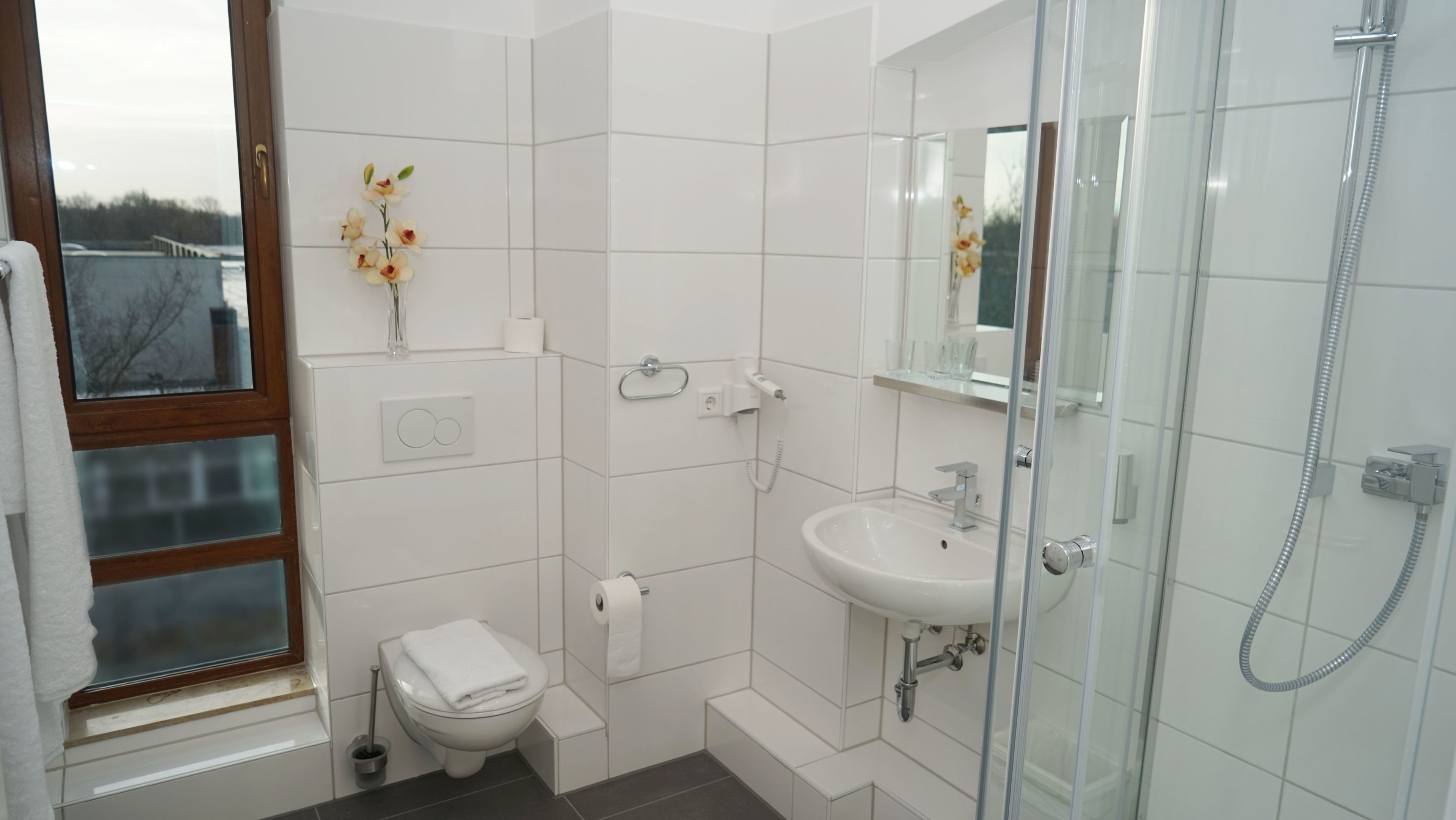 shower, hair dryer, slippers, towels