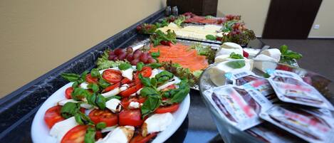 A buffet with various food items including salads, cheeses, and meats.
