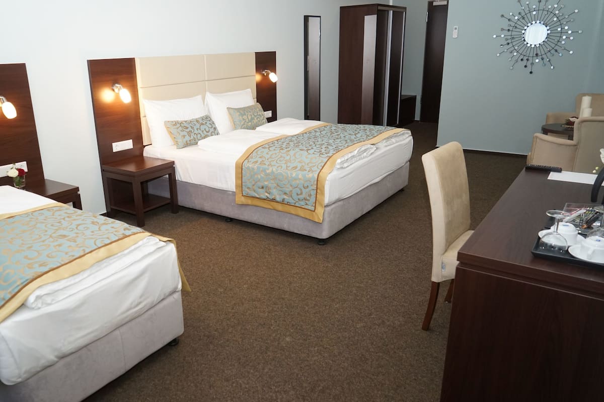 Ein Hotelzimmer mit zwei Betten, einem Schreibtisch und einem Stuhl.