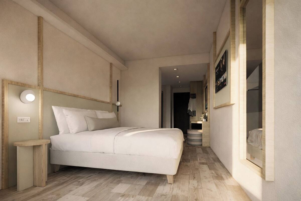 A bedroom with a bed, bedside table, lamp, and a small round table.