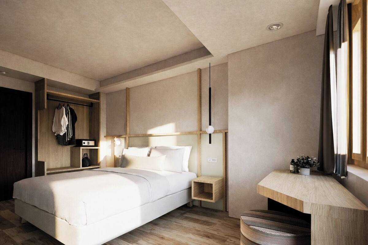 A modern bedroom with a large bed, bedside tables, a built-in wardrobe, and a desk with a plant.