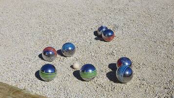 A set of colorful balls on a gravel surface.