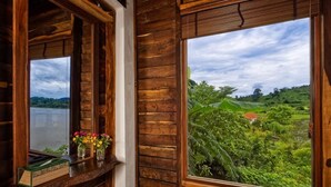 A wooden cabin with large windows overlooking a lush landscape. - Lak Tented Camp (Lak)