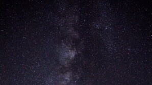 A starry night sky with the Milky Way visible, a modern house with a balcony, and a tree in the foreground. - Lak Tented Camp (Lak)