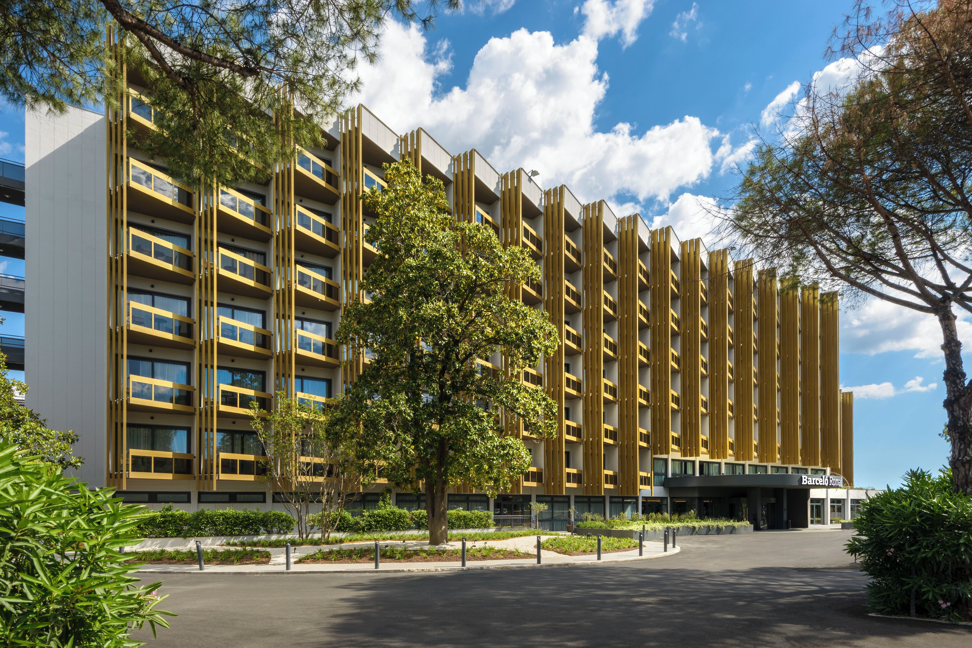 Um edifício moderno com fachada simétrica, várias varandas e uma entrada central.