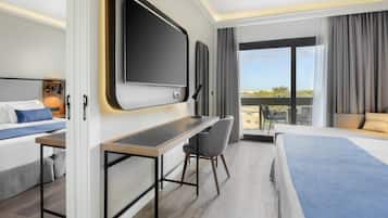 A hotel room with a bed, a desk, a chair, a TV, and a balcony with a view.