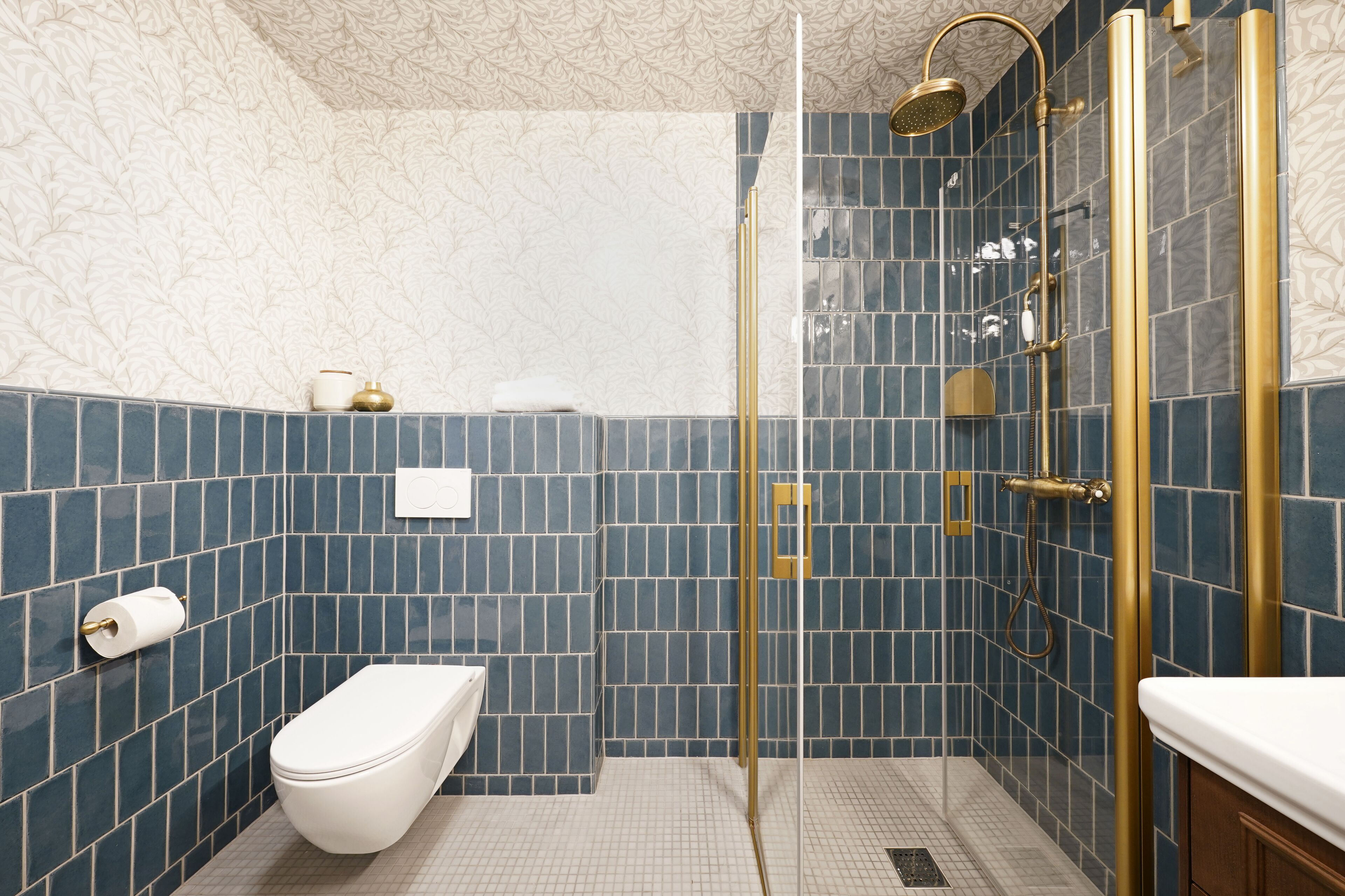 Un baño con inodoro, ducha con puerta de vidrio y lavabo.