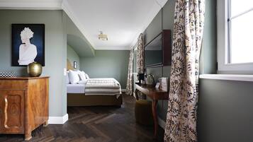 A bedroom with a bed, dresser, and a painting on the wall.