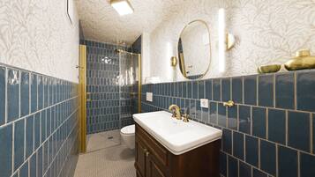 A bathroom with a white sink, gold fixtures, and blue tiles.