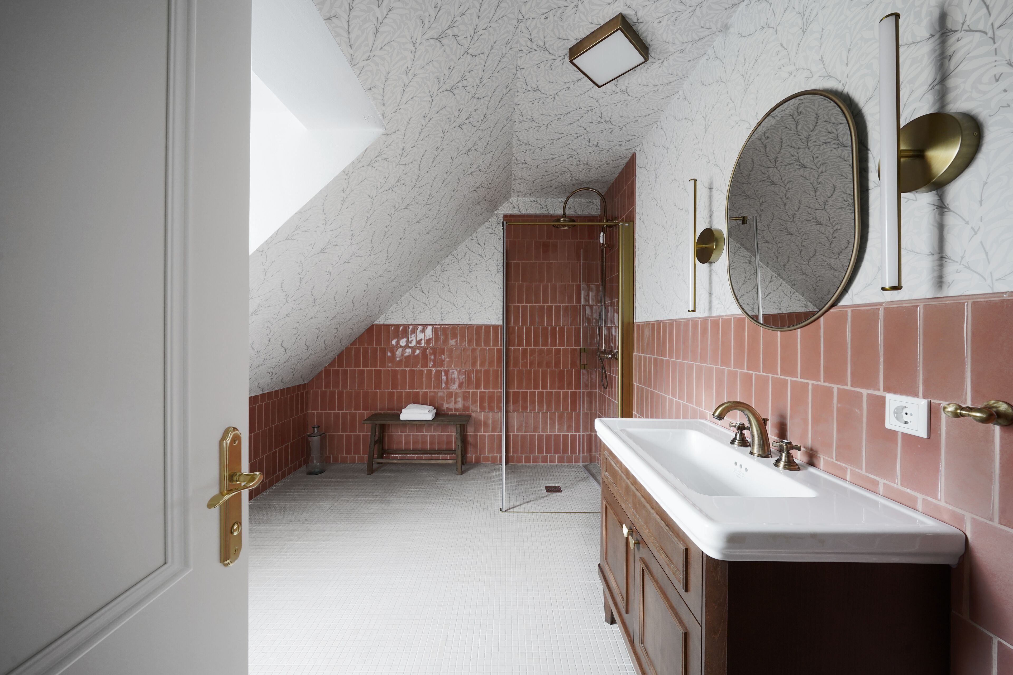 A bathroom with a white sink, a mirror, and a shower area.