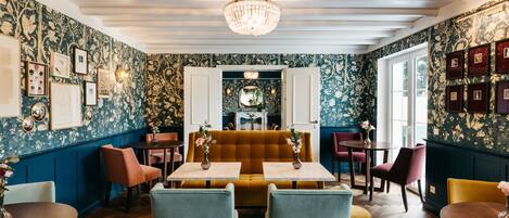 Un restaurante con una cabina central, varias mesas y sillas.