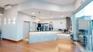 A modern kitchen with a central island, built-in appliances, pendant lighting, and a glass partition. - Portal Hotel Mogi Mirim (Mogi-Mirim)