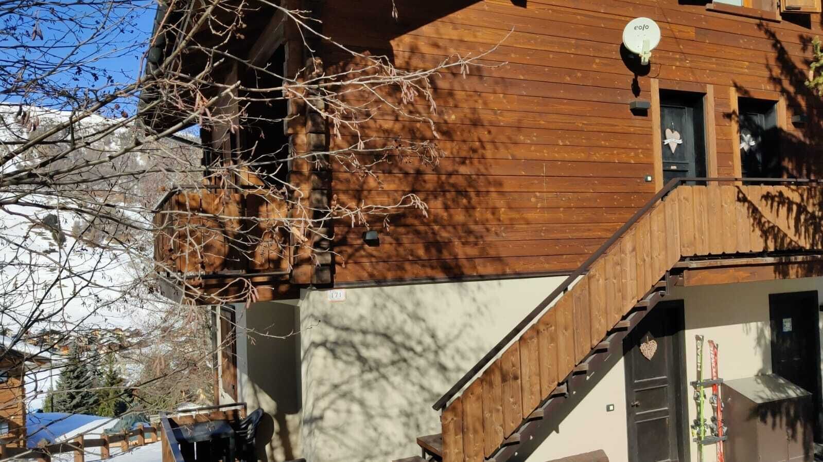 A wooden building with a balcony and a satellite dish.