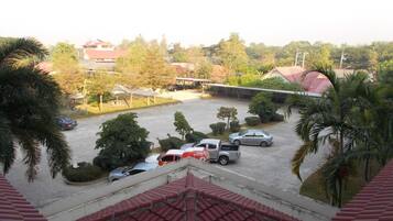 A parking lot with several cars and a truck, surrounded by trees and buildings.