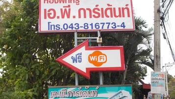 Un cartel con el nombre de un hotel y un número de contacto, un símbolo de WiFi e ilustración de un edificio.