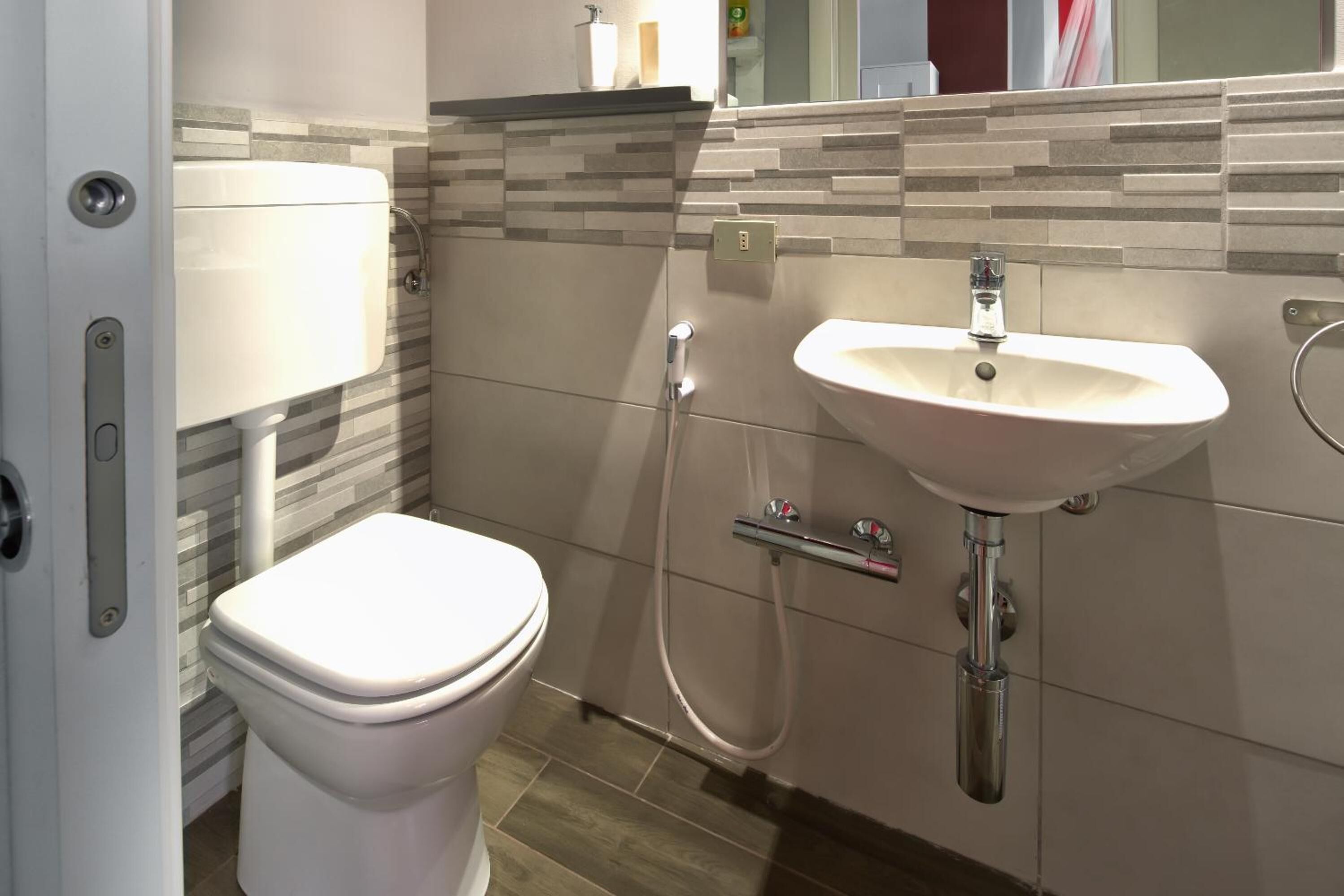 Un bagno moderno con WC, lavandino e doccia.