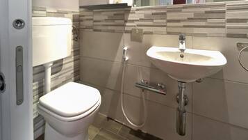 Un bagno moderno con WC, lavandino e doccia.