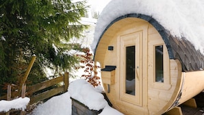 Una cabana de fusta amb un teulat cobert de neu, una porta de fusta i finestres.