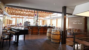 Un grand espace bar agrémenté d’un piano, de barils en bois et d’une enseigne indiquant « CHAMPAGNERIE ».