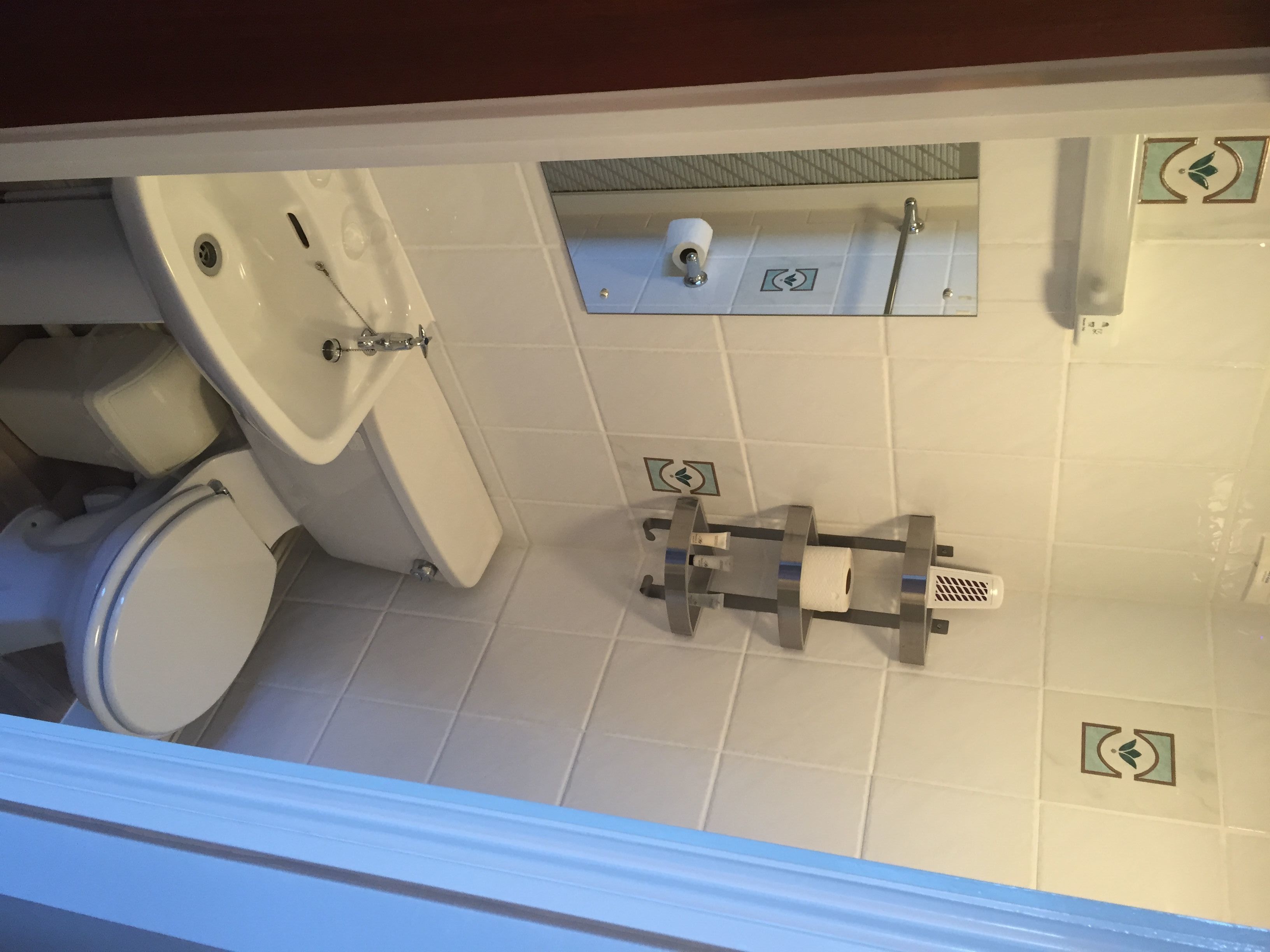 A bathroom with a toilet, sink, and shower area.