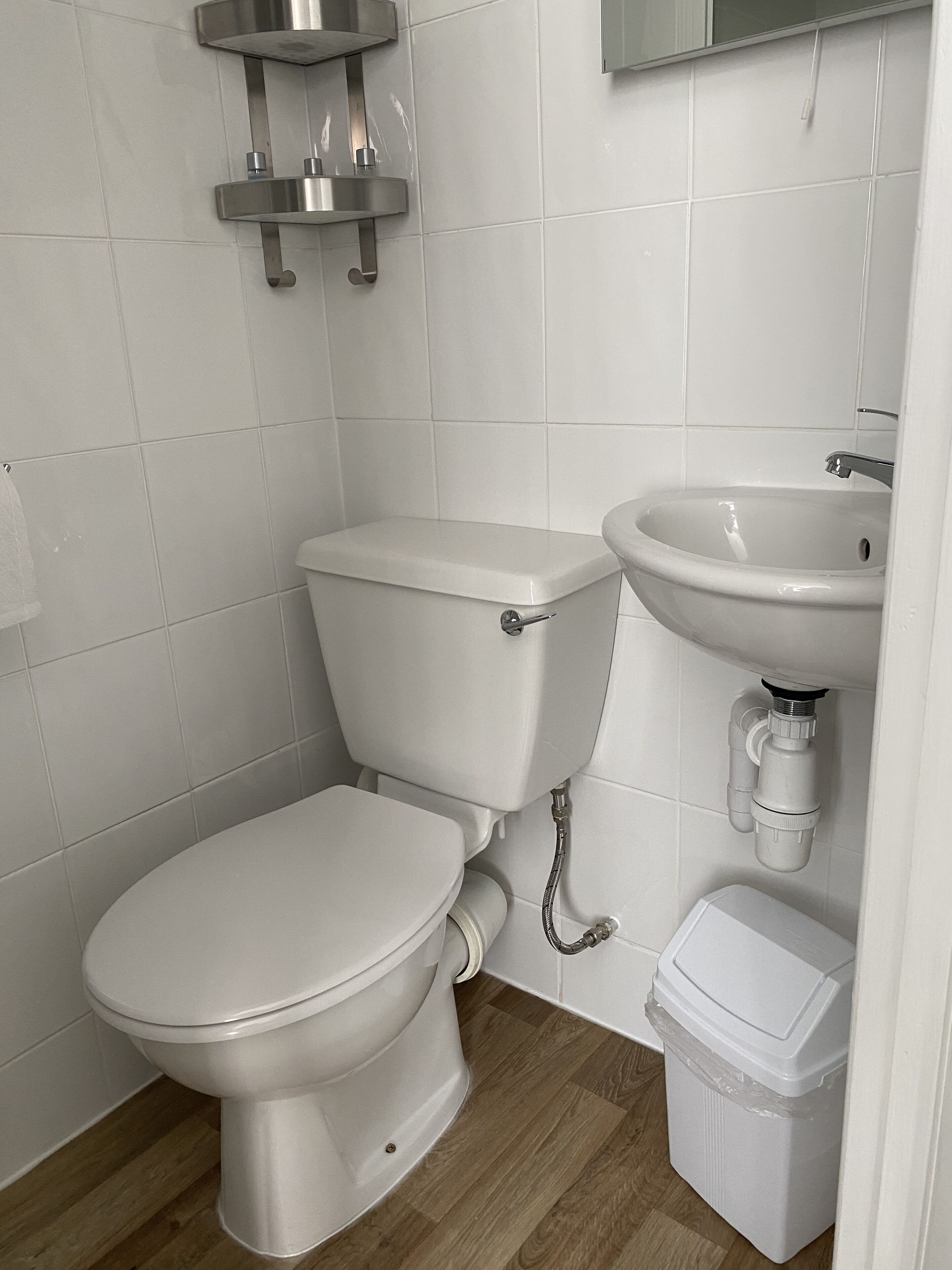 A modern bathroom with a toilet, sink, and storage unit.